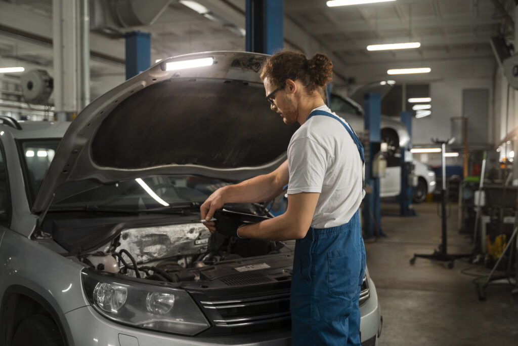 male-mechanic-working-shop-car